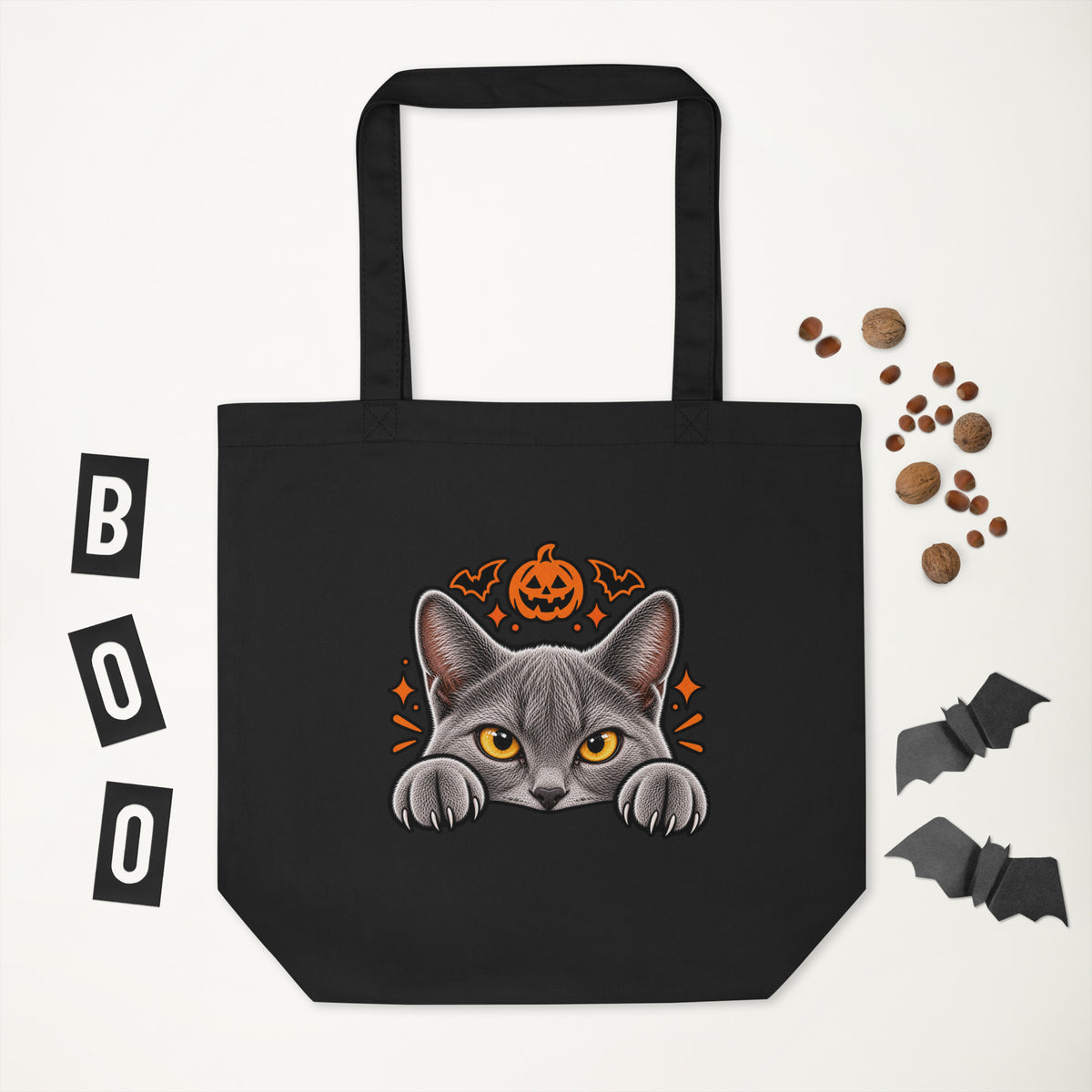 Black Uno the Cat Halloween tote bag featuring a gray cat peeking over the edge beneath an orange pumpkin and bats, displayed against a white background.