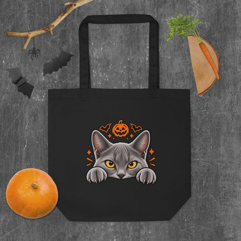 Back of a black Uno the Cat Halloween tote bag featuring a gray cat peeking over the edge beneath an orange jack-o’-lantern with bats and spooky accents.