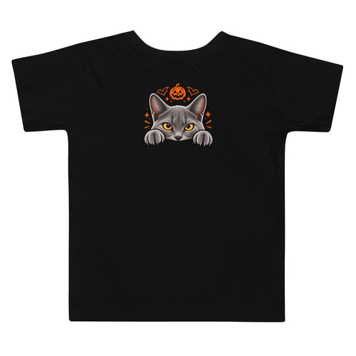 Back of a black toddler Halloween T-shirt featuring Uno the gray cat peeking over an edge beneath an orange jack-o’-lantern and bat accents.
