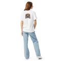 White Uno the Cat Halloween T-shirt featuring a gray cat peeking over the back of the shirt beneath an orange jack-o’-lantern with spooky Halloween accents.